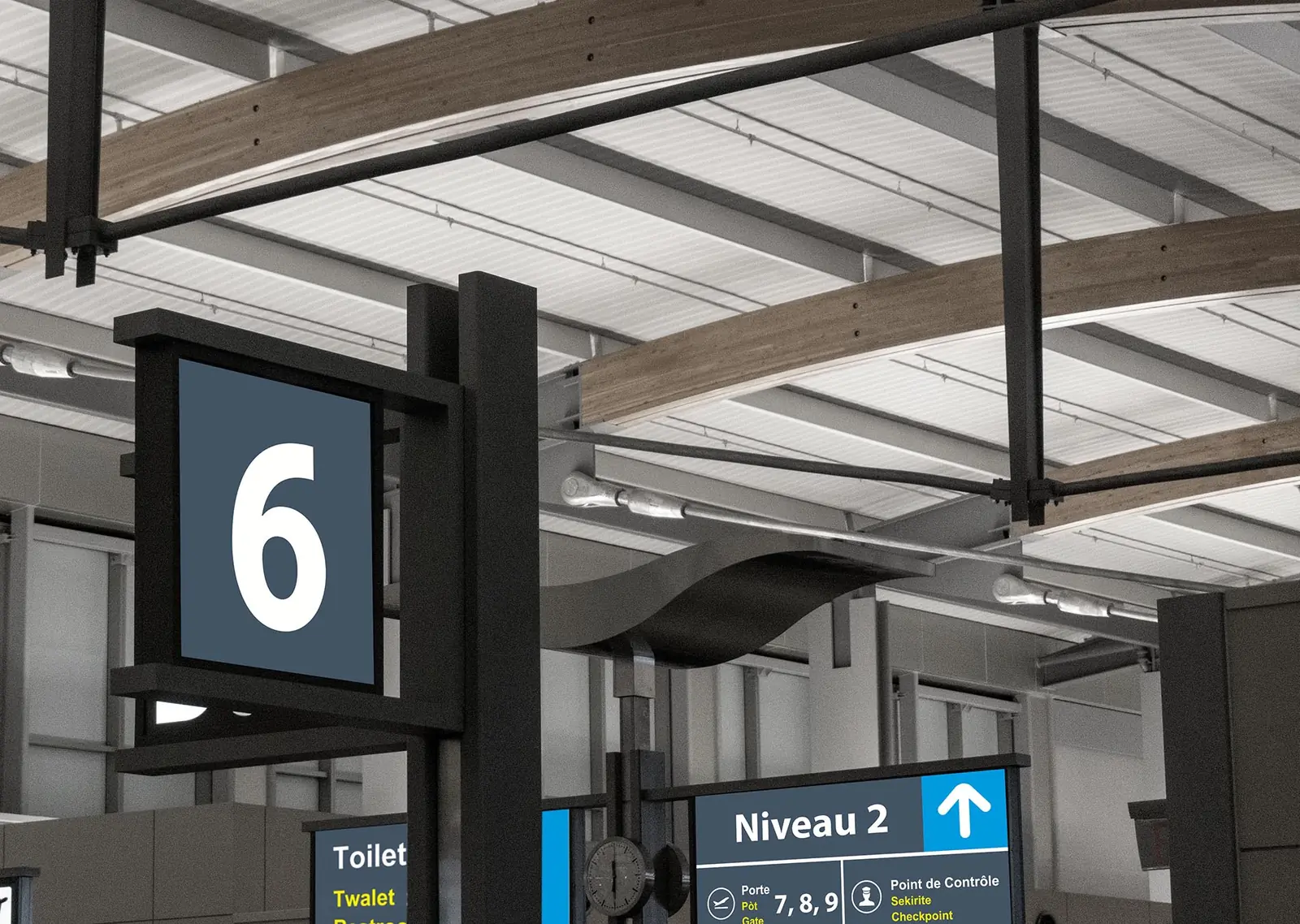 Pylône de la porte 6 et panneau « Niveau 2 » avec des directions en français, créole et anglais.
